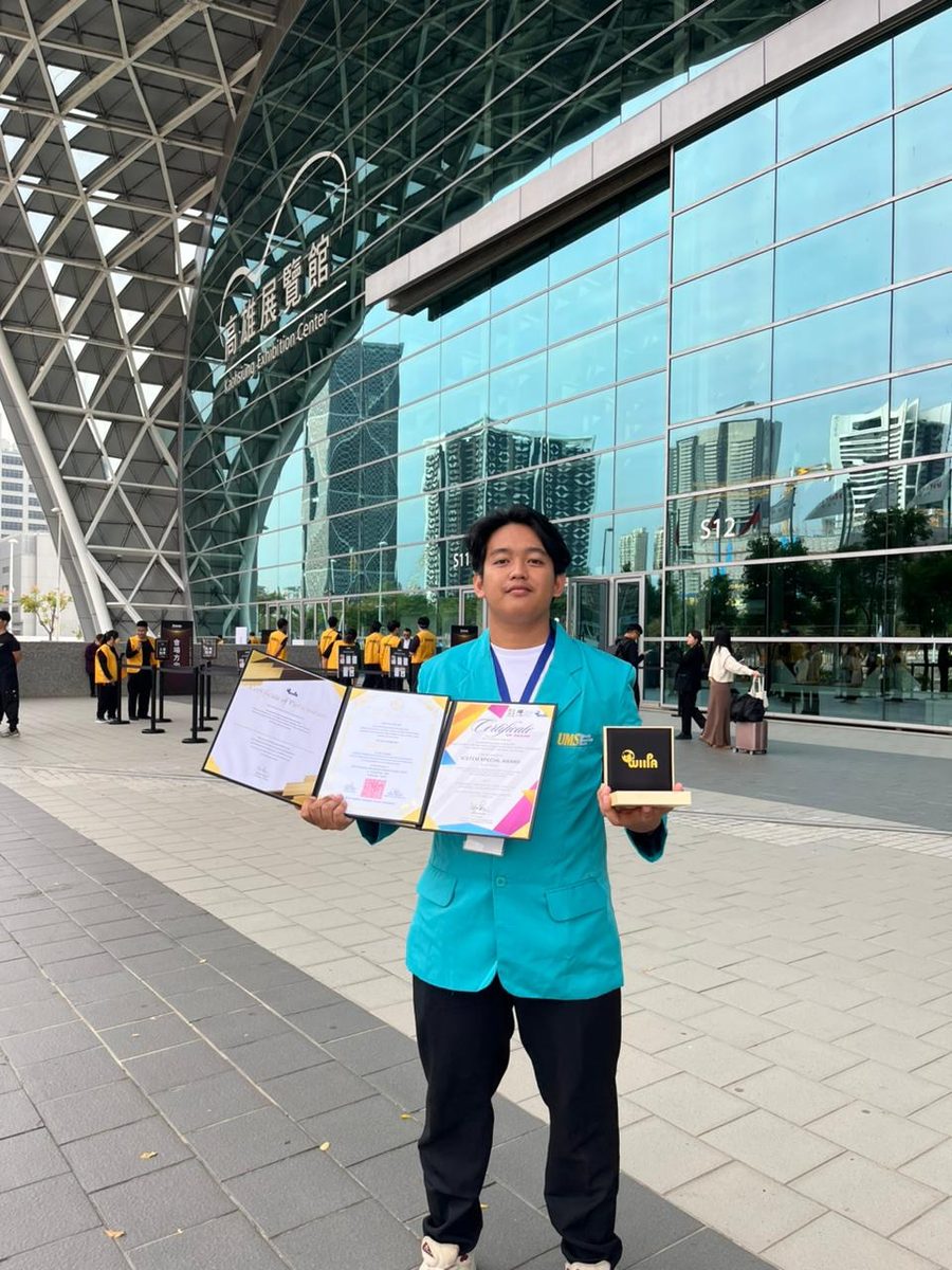 Shafwan holding MomSync's Gold Medal and Special Award certificates at Kaohsiung Exhibition Center, Taiwan